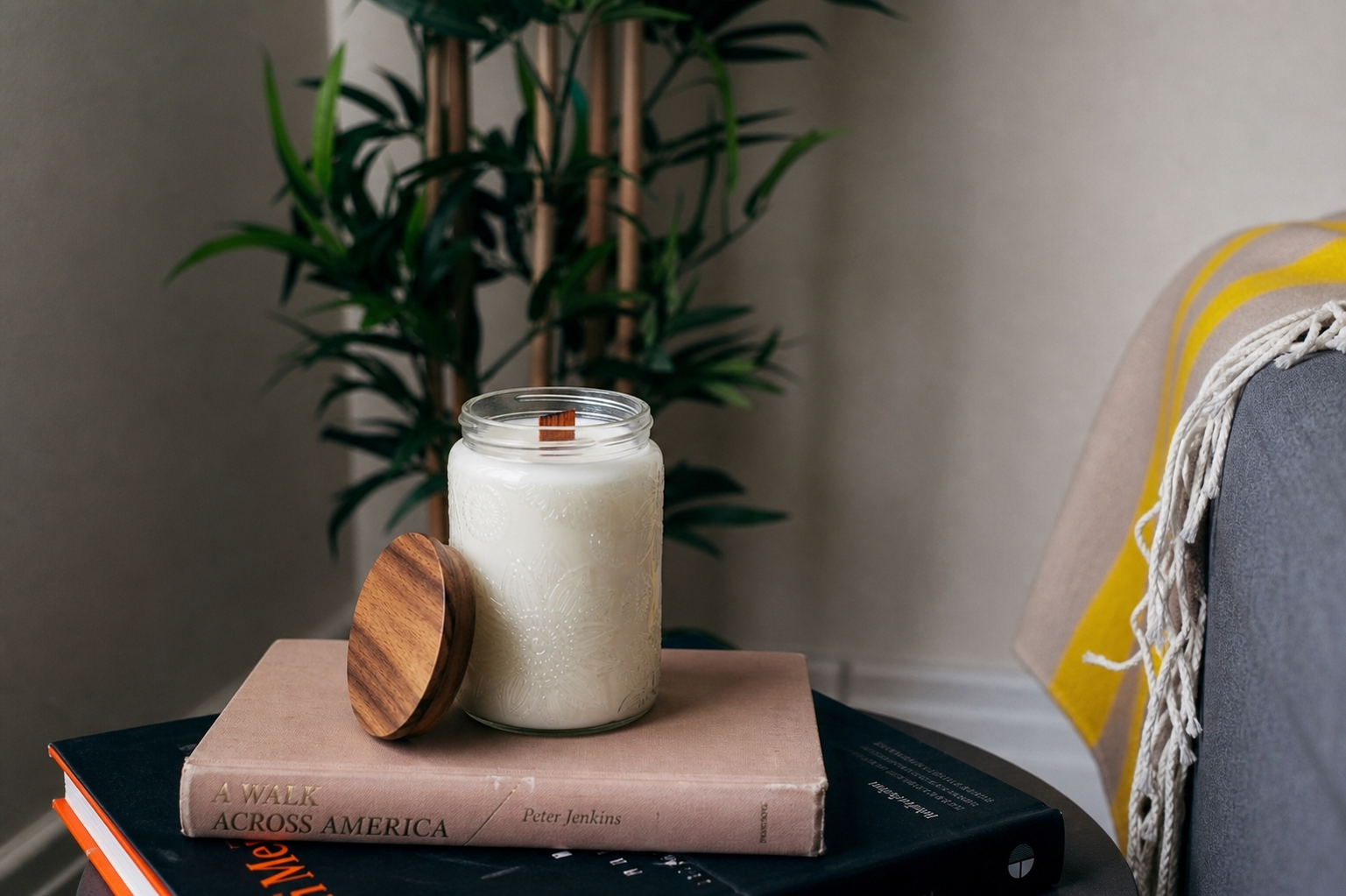 Sincero Home — Vela artesanal XL de soja con mecha de madera — Open candle lifestyle photo on books